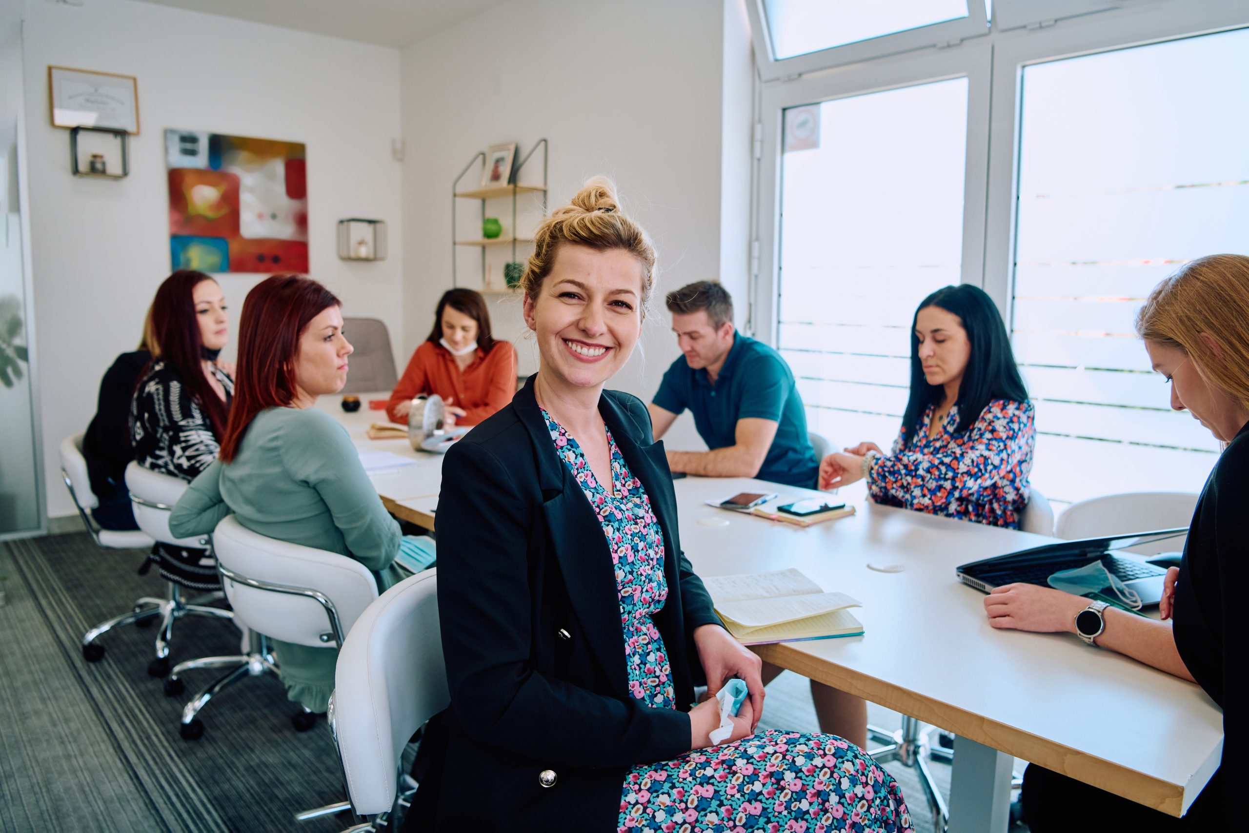 Diverse Business Team Discussing Projects in a Modern Glass Office.